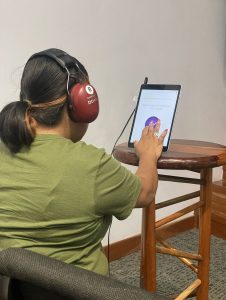 A woman testing their hearing with SHOEBOX QuickTest