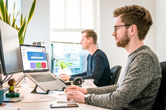 Workplace Audiology Onboarding Services - People working at a desk using computers