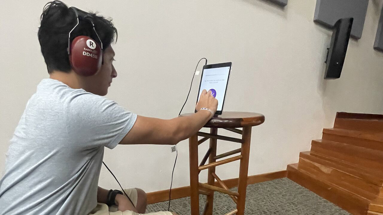 A young man testing their hearing with SHOEBOX QuickTest