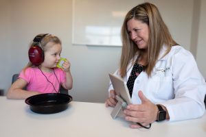 Audiologist conducts conditioned play audiometry test